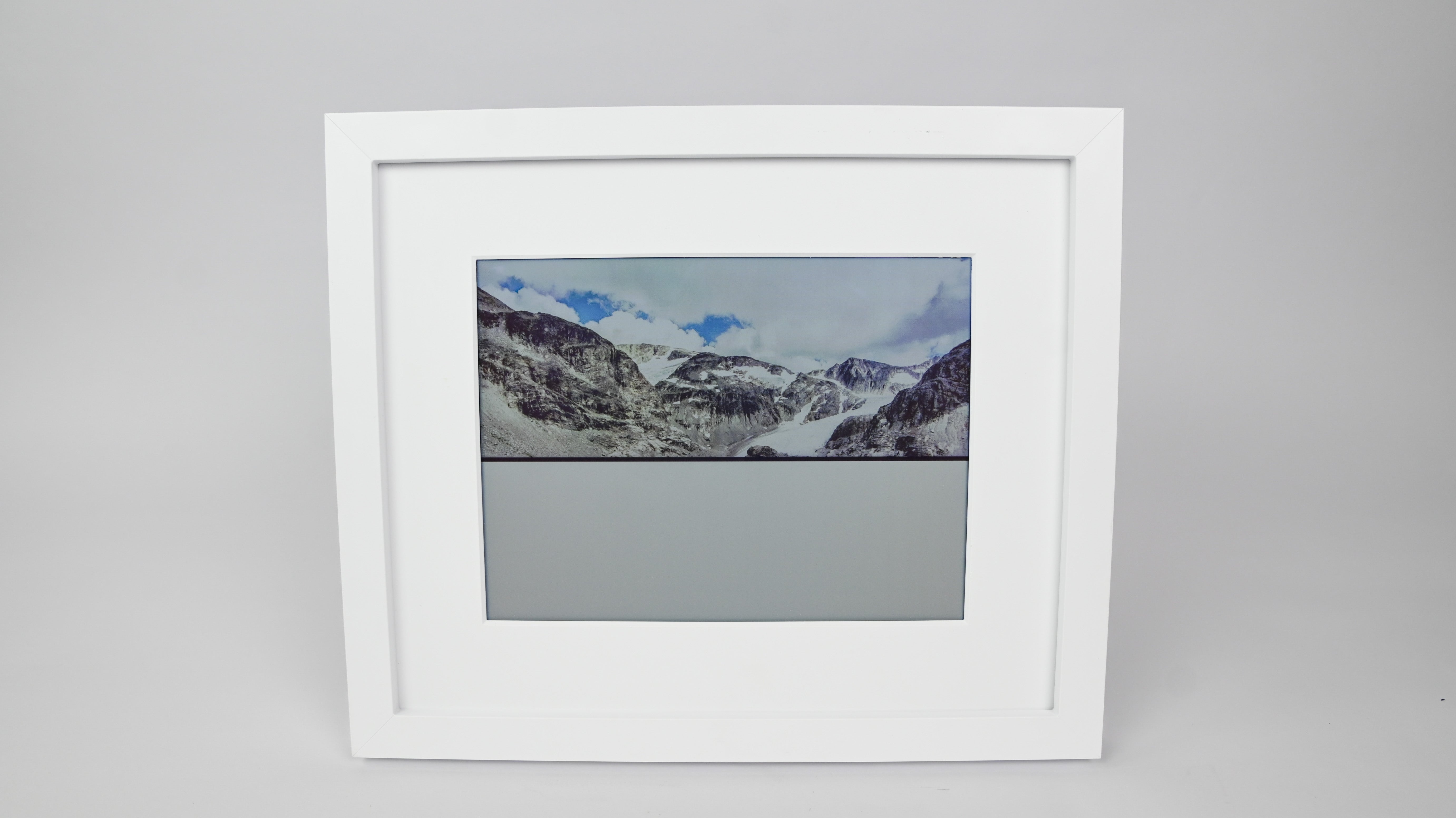 Framed photograph of a mountain landscape on a gray background #white